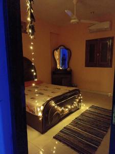 Schlafzimmer mit einem Bett mit Beleuchtung und einem Spiegel in der Unterkunft Private room in Dahab,10 minutes to sea in Dahab
