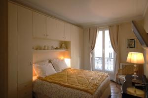 パリにあるTwo-Bedroom Apartment Champs-Elyséesのベッドルーム1室(ベッド1台、大きな窓付)