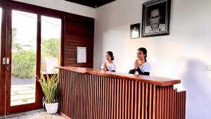 two women sitting at a bar in a room at Lumbung Bukit Resort Uluwatu in Uluwatu