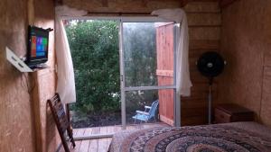 - une chambre avec une porte s'ouvrant sur un balcon doté d'une télévision dans l'établissement La Cabañita del Sur, à Mar del Plata