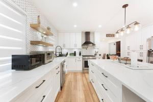 a white kitchen with white cabinets and a microwave at Luxury Home In Burnaby/Metrotown/SFU in Burnaby