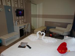 two swans sitting on a bed in a bedroom at Hotel Moderno in Grumello del Monte