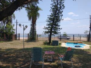 un patio con 2 sillas, una mesa y una piscina en LA ASCENSIÓN PASO DE LA PATRIA en Paso de la Patria