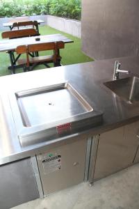 a kitchen counter with a sink and a table at The Jack Backpackers in Cairns