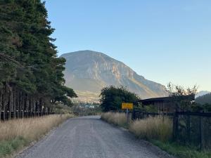 a dirt road with a mountain in the background at Cabaña Pampa Pinuer Coyhaique in Coihaique