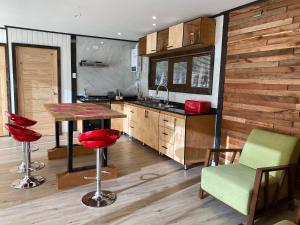 a kitchen with a table and some chairs and a counter at Cabaña Pampa Pinuer Coyhaique in Coihaique