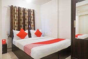 1 dormitorio con 1 cama grande con almohadas de color naranja en River View Near Shaniwar Wada, en Pune