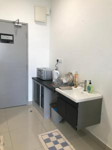 a kitchen with a sink and a microwave on a counter at David Studio Unicity, Seremban 3 in Seremban