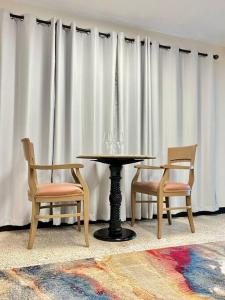 a table and two chairs in front of a curtain at Los Roires Beach Apartments in Fajardo