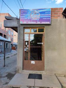 una puerta a un restaurante con un cartel en Alojamiento la Gran Estación en Uyuni