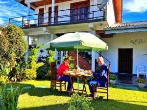 two people sitting at a table under an umbrella at RC AWKWARD in Nuwara Eliya