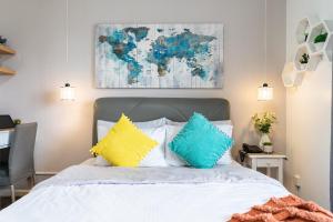 una camera da letto con un letto con cuscini blu e gialli di AMANI 729, 3 Minutes to Airport, 100mbps Wi-Fi, Free Netflix a Pusok