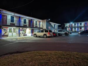un groupe de voitures garées sur un parking la nuit dans l'établissement Executive Inn Coopersburg, à Coopersburg