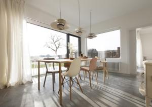 Logieslogees في Tielrode: غرفة طعام مع طاولة وكراسي ونافذة كبيرة