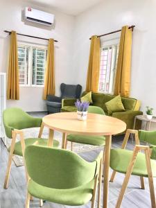 sala de estar con mesa y sillas verdes en Teratak Ar-Rayyan x Villa Abi, en Batu Kurau
