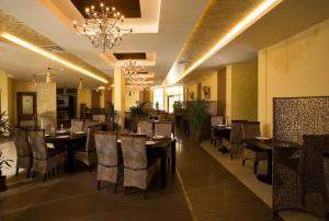 une salle à manger avec tables et chaises et un lustre dans l'établissement Laguna Beach Resort & Spa, à Sozopol