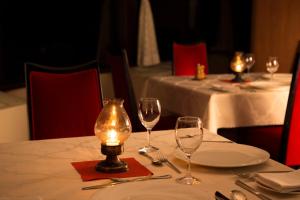 a table with wine glasses and a candle on it at Manza Prince Hotel in Tsumagoi