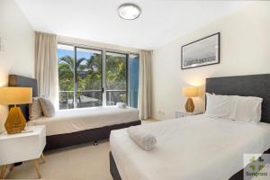 1 dormitorio con 2 camas y ventana grande en Azzura Greens Resort en Gold Coast