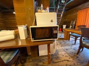 a microwave sitting on top of a table at BAYMARINAログハウス in Sakaide