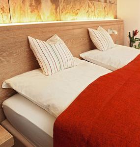 1 cama roja y blanca con 2 almohadas en Hof31, en Hilchenbach