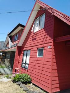 una casa roja con un revestimiento rojo en Casa Valle Volcanes, en Puerto Montt