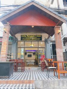 a restaurant with tables and chairs in a building at Lucky Backpacker Hostel in Vientiane