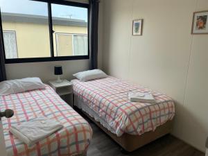 a room with two beds and a window at Lakes Main Holiday Park in Lakes Entrance