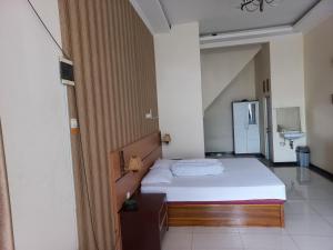 een kleine slaapkamer met een bed en een wastafel bij Riki Guesthouse Syari'ah in Jepara