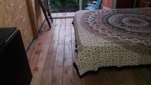1 dormitorio con 1 cama y suelo de madera en La Cabañita del Sur en Mar del Plata