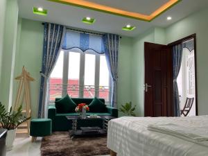 1 dormitorio con sofá verde y ventana en An Na Bình Homestay en Hoi An