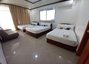 a hotel room with two beds and a couch at Seven Waves Beachfront Residence 