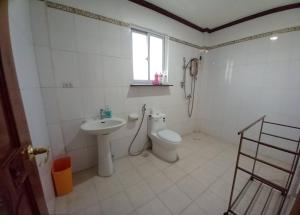 uma casa de banho com um WC, um lavatório e um telefone em Seven Waves Beachfront Residence 
