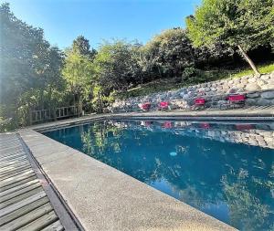 a swimming pool with a bench and a rock wall at Refugios de la Montaña in San José de Maipo