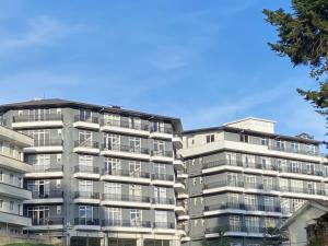 an apartment building in front of a blue sky at THE WIND LILY - Lake View Luxury Apartment in Nuwara Eliya
