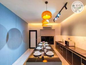 een keuken met een lange tafel met borden erop bij Gran Estancia Villa @ JBcity Home in Johor Bahru