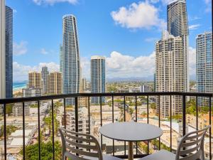 balcón con mesa, sillas y vistas a la ciudad en Serain Residences On View en Gold Coast