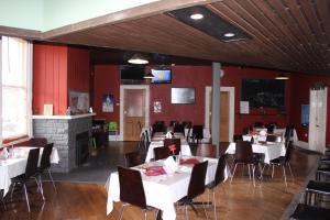 a dining room with tables and chairs and a fireplace at St Marys Hotel and Bistro in Saint Marys