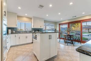 a kitchen with white cabinets and a table and chairs at 5bdr park lane villa-basketball court-pool-views in Los Angeles