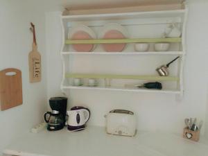 a kitchen counter with shelves and dishes on it at Fotinos House Skiathos in Skiathos