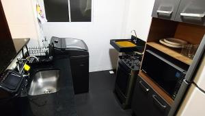 a small kitchen with a stove and a sink at Apto Executivo Ravena in Campo Grande