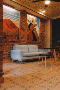 Bunde Haus Hotel EXPRESS BOUTIQUE في إباغويه: غرفة معيشة مع أريكة ولوحة على الحائط