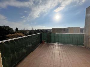 balkon z zielonym płotem na szczycie budynku w obiekcie Charmant T2 avec terrasse, climatisation, parking - Valras-Plage - FR-1-701-6 w mieście Valras-Plage