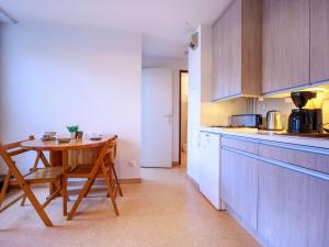 a kitchen with a wooden table and a small table with a chair at Appartement 4 pers, St Lary, animaux acceptés - FR-1-296-456 in Saint-Lary-Soulan +17 photos