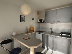 une petite cuisine avec une table et un évier dans l'établissement Appartement Valras-Plage, 2 pièces, 4 personnes - FR-1-701-18, à Valras-Plage