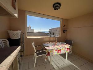 een kleine tafel en stoelen in een kamer met een raam bij Appartement Valras-Plage, 1 pièce, 4 personnes - FR-1-701-21 in Valras-Plage