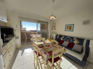 een keuken en een woonkamer met een tafel en een bank bij Appartement Valras-Plage, 1 pièce, 4 personnes - FR-1-701-21 in Valras-Plage