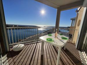 Biały stół na balkonie z widokiem na ocean w obiekcie T3 avec terrasse, parking, proche plage et commerces - FR-1-701-16 w mieście Valras-Plage
