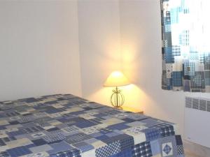 sypialnia z niebiesko-białym łóżkiem i lampą w obiekcie Maison cosy avec terrasse, 2 chambres, piscine partagée, proche plage et commerces, Gruissan - FR-1-229-832 w mieście Gruissan