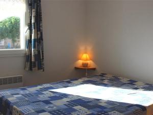 sypialnia z łóżkiem, lampą i oknem w obiekcie Maison cosy avec terrasse, 2 chambres, piscine partagée, proche plage et commerces, Gruissan - FR-1-229-832 w mieście Gruissan