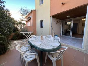 einen Tisch und Stühle auf einer Terrasse in der Unterkunft Appartement Valras-Plage, 3 pièces, 4 personnes - FR-1-701-27 in Valras-Plage